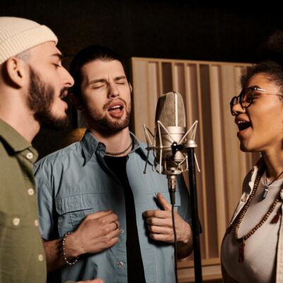 3 people singing into a microphone